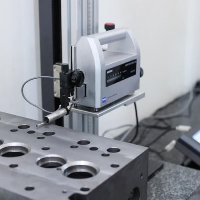 uality assurance equipment using a profilometer surface roughness tester to measure the Ra surface finish of a custom CNC turned component.